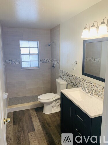 A bathroom with a toilet, sink, and shower.