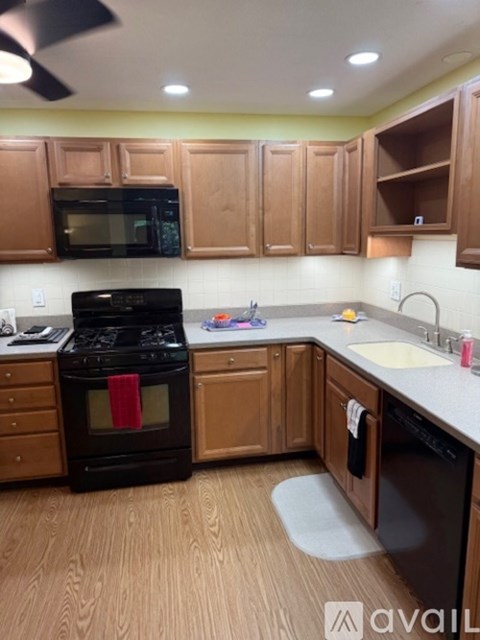 A kitchen with wooden cabinets and a black stove top oven.