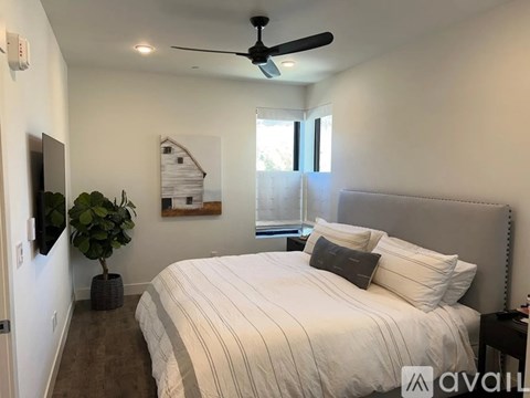 A bedroom with a large bed and a ceiling fan.
