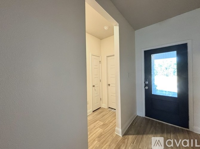 A hallway with a door on the right and a window on the door.