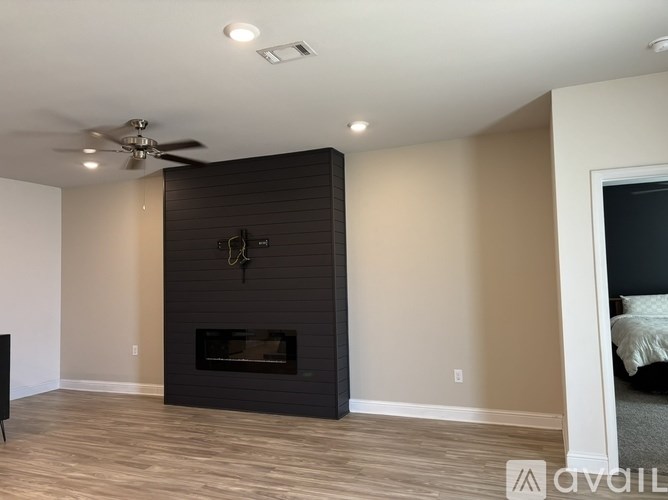 A modern living room with a fireplace and a ceiling fan.