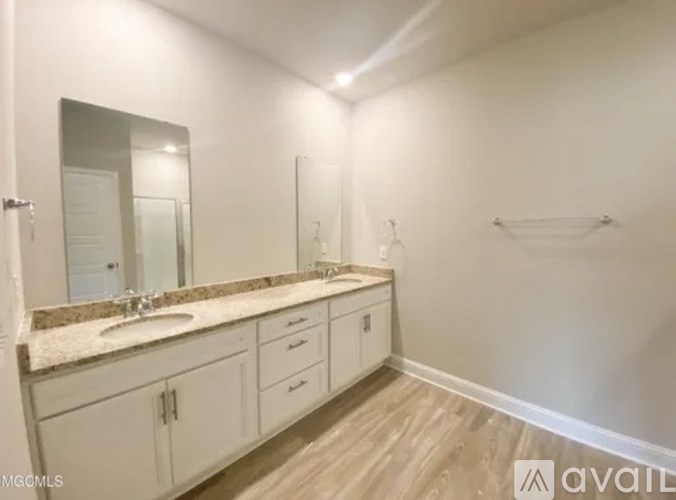 A bathroom with a sink, mirror, and cabinets.