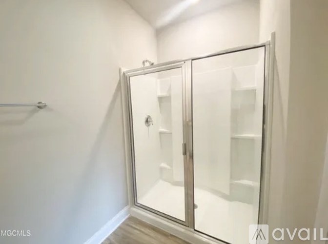 A white bathroom with a glass shower door.