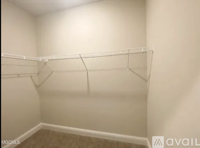 Empty white closet with a shelf and a hanger.