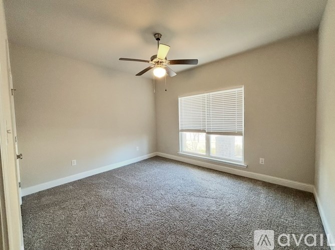 A room with a ceiling fan and carpeted floor.