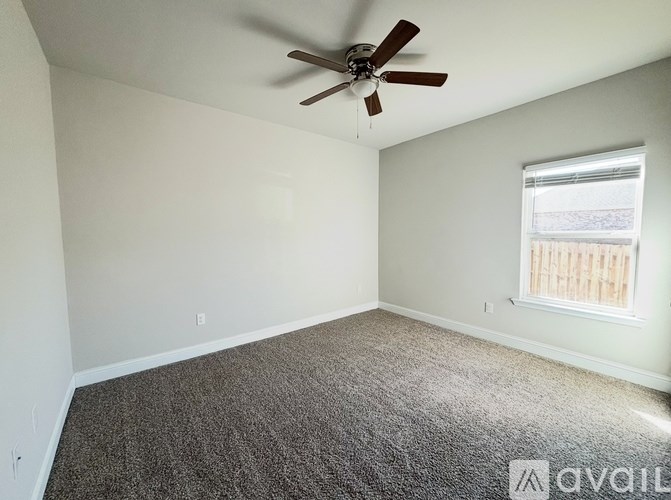 A room with a ceiling fan and carpeted floor.