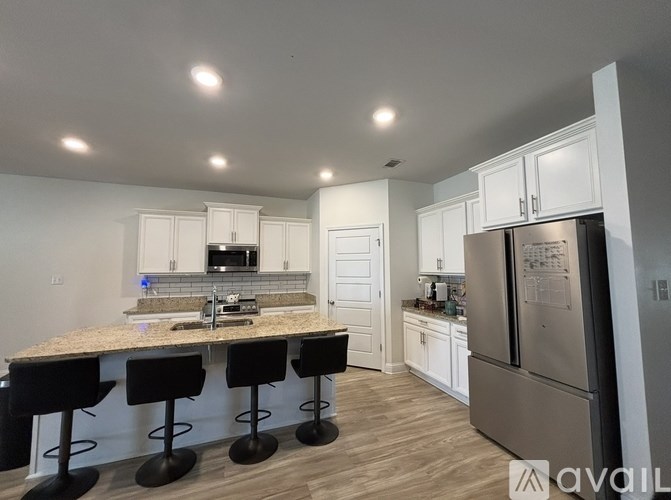 A kitchen with a granite countertop and bar stools.