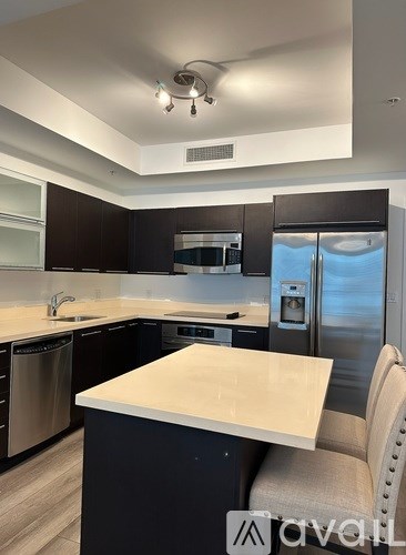 A kitchen with a table and chairs in front of a refrigerator.