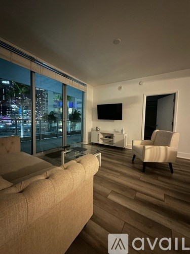 A living room with a couch, chair, and television.