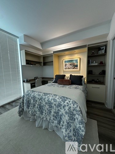 A bedroom with a bed, a chair, and a painting on the wall.