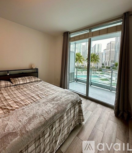 A bedroom with a large bed and a view of the city.