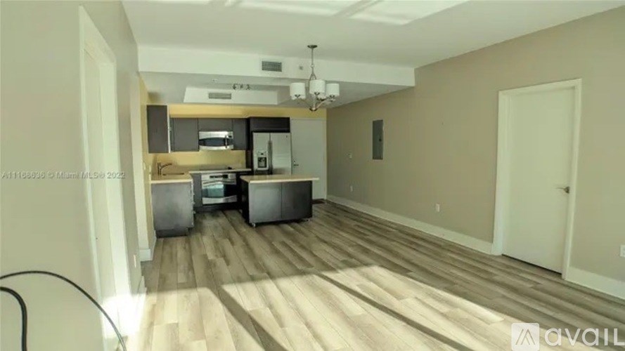 A kitchen area with wooden flooring and a countertop with a sink.