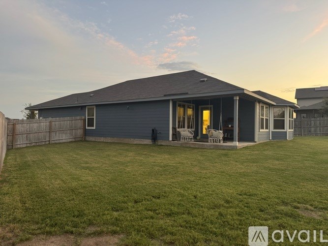 A house with a grey roof and a fence in front of it.