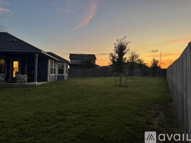 A house with a lawn and a fence in the foreground.