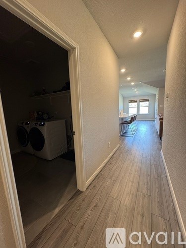 A hallway with a doorway leading to a kitchen area.