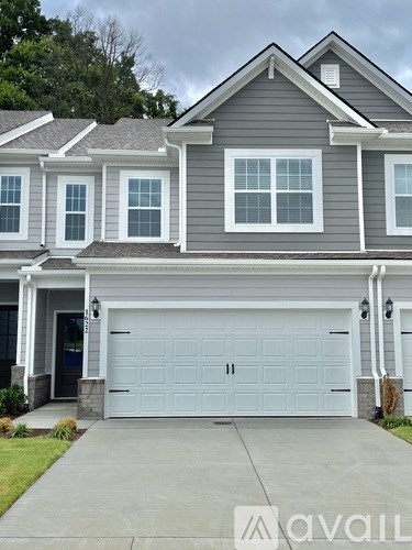 A two-story house with a garage and a driveway.