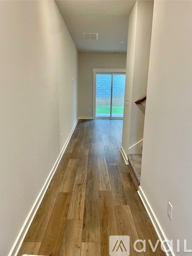 A long hallway with wooden floors and white walls.