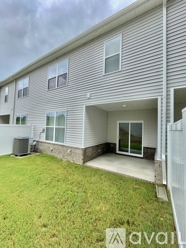 A house with a grey siding and a white fence.