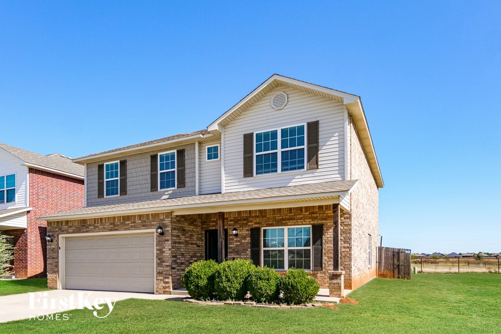 A house with a garage and a driveway in front.