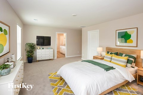 A bedroom with a large bed and a flat screen TV.