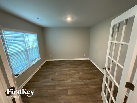 A room with wooden flooring and a white door.