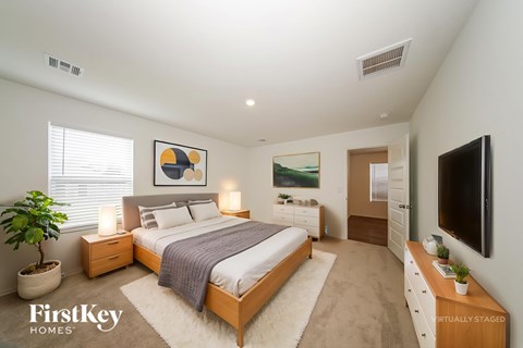 A bedroom with a bed, nightstands, and a television.