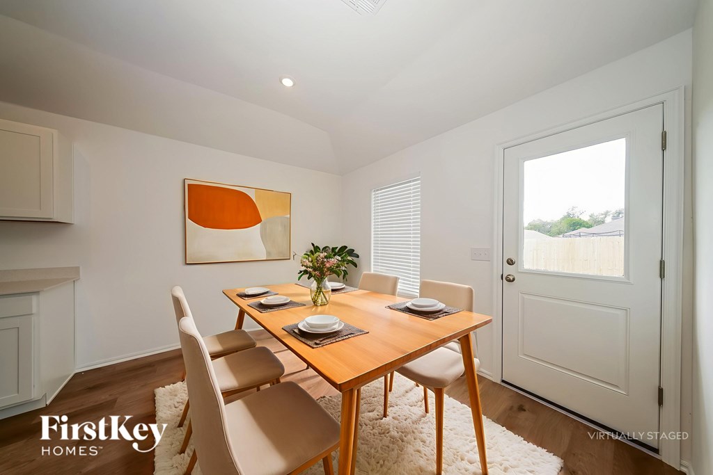 A dining room with a wooden table and chairs.