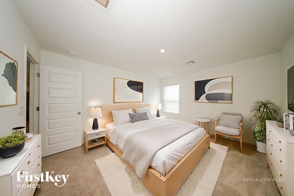 A bedroom with a bed, nightstand, and chair.