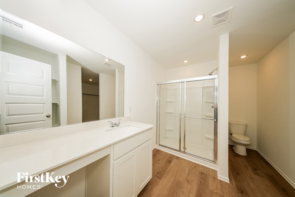 A white bathroom with a walk in shower.