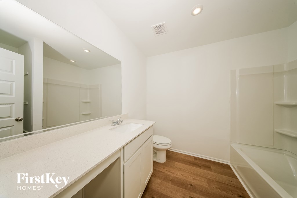 A white bathroom with a FirstKey Homes logo.
