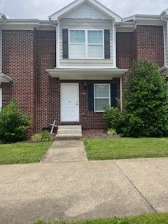A brick house with a white door and a small porch.
