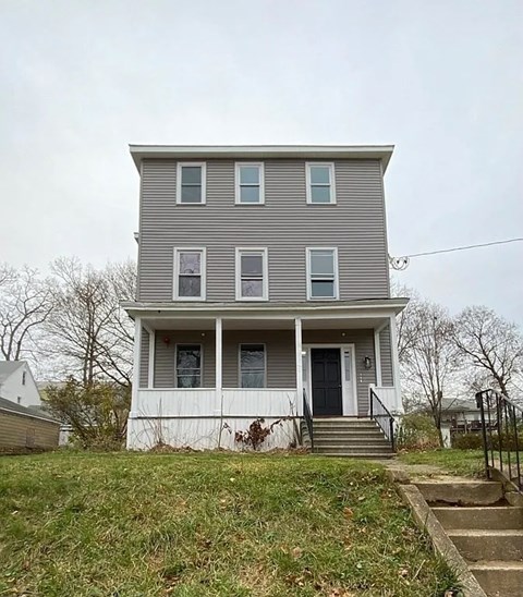 A two-story house with a front porch and a black door.