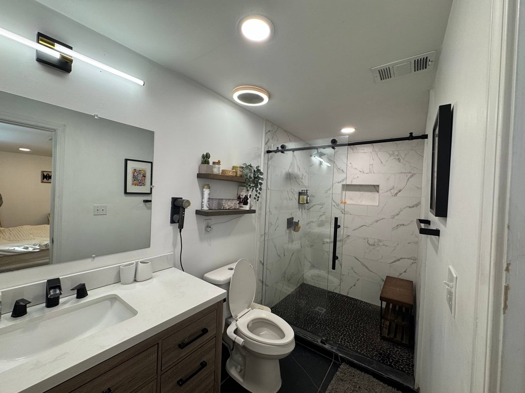 A bathroom with a toilet, sink, and shower.