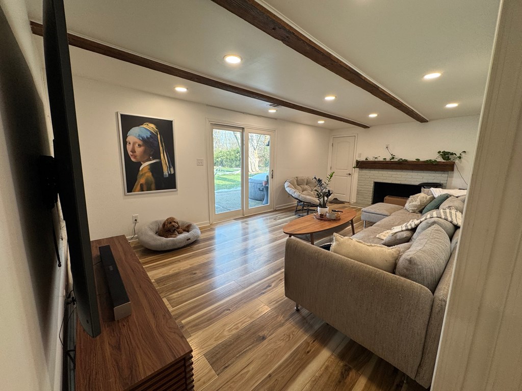 A dog is sitting on a white dog bed in a living room.