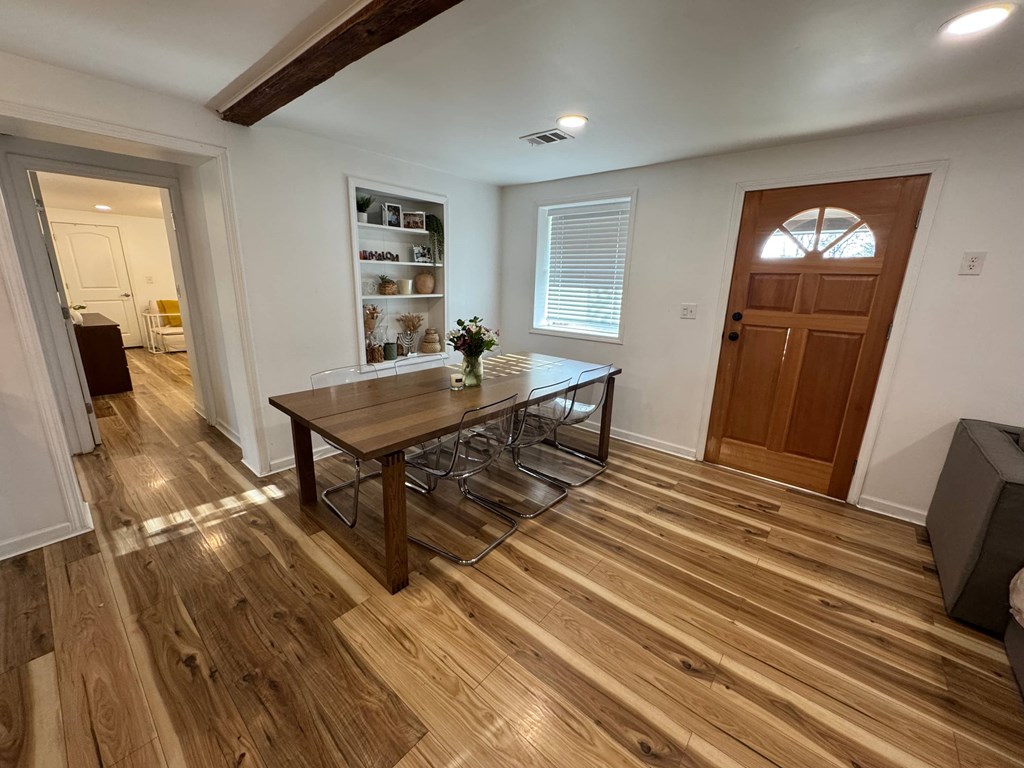 A room with a wooden floor and a brown door.
