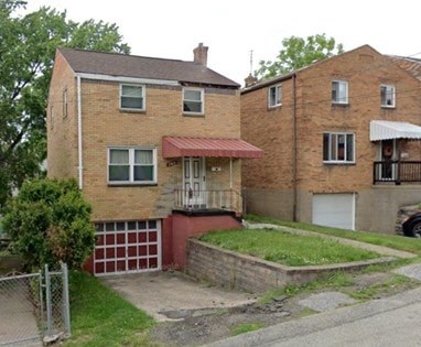 A red brick house with a white garage door.