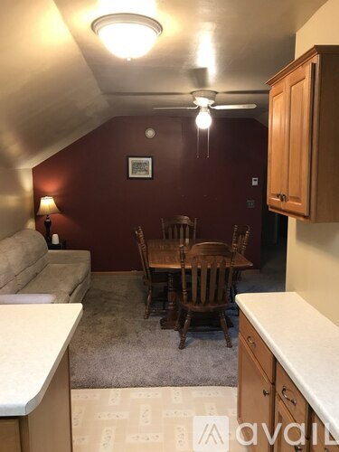 A living room with a couch, chairs, and a ceiling fan.