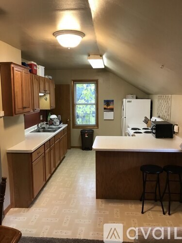 A kitchen with wooden cabinets and a white fridge.