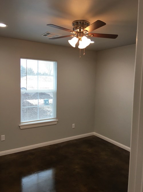 A room with a ceiling fan and a window.