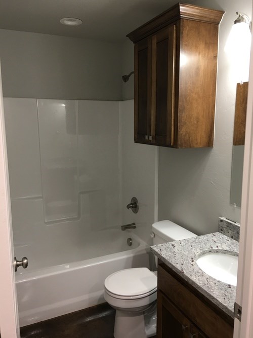 A white toilet sits in a bathroom next to a sink.