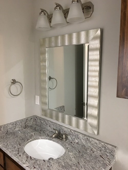 A bathroom sink with a large mirror above it.