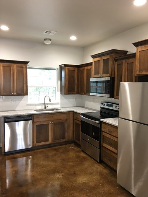 A kitchen with brown cabinets and stainless steel appliances.