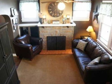 A living room with a fireplace and a clock on the wall.