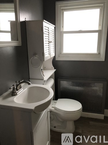 A white toilet sits next to a sink in a bathroom.