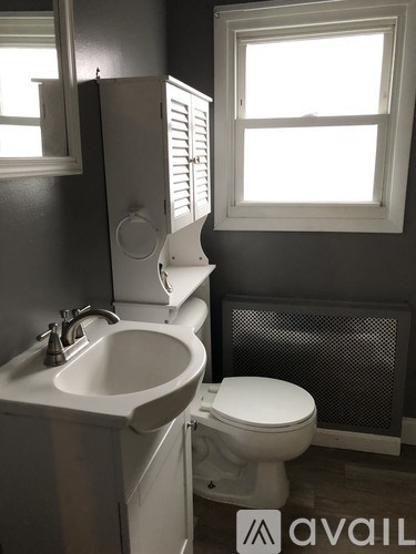 A white toilet sits next to a sink in a bathroom.