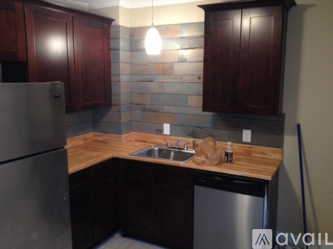 A kitchen with wooden cabinets and a stone backsplash.
