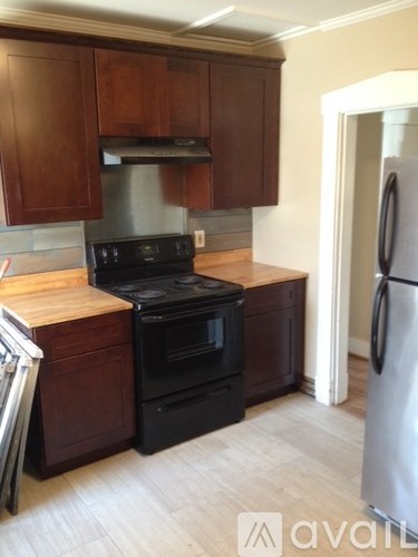 A kitchen with wooden cabinets and a black stove top oven.