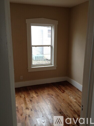 A room with a window and wooden flooring.