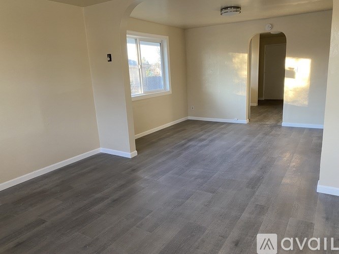 A room with wooden flooring and a window.