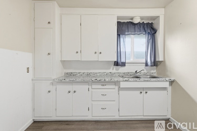 A bathroom with a white sink and a window.